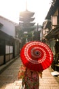 Japanese girl in Yukata with red umbrella in old town Kyoto