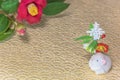 A Japanese greeting card with a Tsubaki flower also called the winter rose and a cute rat figurine for the 2020 year of the mouse