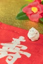 A Japanese greeting card with a Tsubaki flower also called the winter rose and a cute rat figurine for the 2020 year of the mouse