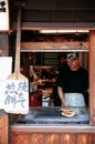Japanese guy grilling Senbei rice cracker on stove at Sanmachi S