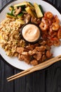 Japanese hibachi lunch made of fried rice, shrimp, steak and vegetables close-up on the table. Vertical top view Royalty Free Stock Photo