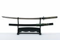 Japanese iaido sword in black wooden stand and white background.