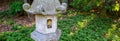 Japanese inspired pagoda lantern in a woodland garden, sunbeams shining in