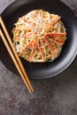 Japanese Kani Salad is a popular side dish with crunchy vegetables and savory crab sticks closeup in the plate. Vertical top view