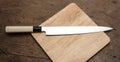 Japanese Knife on wooden square chopping block from top view Royalty Free Stock Photo