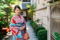 Japanese lady standing in garden in sunny day