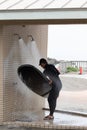 Japanese man in black wetsuit cleaning up his surfboard Royalty Free Stock Photo