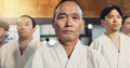 Japanese man, face and sensei in aikido for respect, honor and dignity with group in martial arts class. Portrait of
