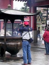 A Japanese man prays at the giant censer before entering the temple