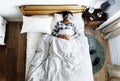 Japanese man sleeping on bed with eye mask Royalty Free Stock Photo