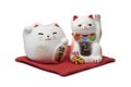 Japanese maneki neko, lucky cats on a red pillow Royalty Free Stock Photo