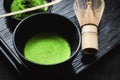 Japanese matcha green tea at homemade clay bowl with bamboo whisk