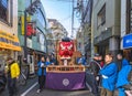 Japanese men dressed in happi kimono pushing a parade float with a giant tengu in Shimokitazawa.