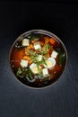 Japanese miso soup in ceramic bowl on black stone table, copy space. Asian miso soup with tofu. Royalty Free Stock Photo