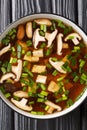 Japanese miso soup with shiitake mushrooms, tofu and green onions close-up in a bowl. Vertical top view Royalty Free Stock Photo