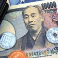 Japanese money, notes and coins are near the diary. 10,000 yen banknote close-up. News about the economy, the Bank of Japan Royalty Free Stock Photo