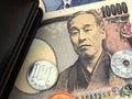 Japanese money, notes and coins are near the diary. 10,000 yen banknote close-up. News about the economy, the Bank of Japan and Royalty Free Stock Photo