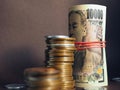 Japanese money: ten thousand yen bills and stacks of coins close-up. Focus on the number 10000. Banknotes are rolled up and tied Royalty Free Stock Photo