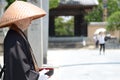 Japanese monk standing in front of the temple for donation from