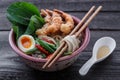 Japanese noodle soup topped with tempura shrimps, egg and greens, close view Royalty Free Stock Photo