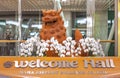 Japanese Okinawan lion Shisa sculpture decorated with white orchids flowers in the Welcome Hall of Naha Airport in the south of