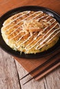 Japanese okonomiyaki on a table close-up and chopsticks. vertica Royalty Free Stock Photo