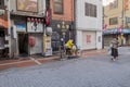 A japanese old woman in yellow jacket is riding her yellow bicycle