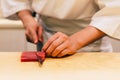 Japanese Omakase Chef cut bluefin tuna Otoro in Japanese neatly by knife on wooden kitchen counter for making sushi. Royalty Free Stock Photo