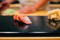 Japanese Omakase in Edo Style: Close up Otoro (Fatty Tuna) Sushi served on glossy black plate.