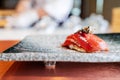 Japanese Omakase meal: Aging Raw Akami Tuna Sushi adds with sliced truffle served by hand on a stone plate.