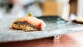 Japanese Omakase meal: Shima Aji Sushi with fresh wasabi served by hand on a stone black plate. Royalty Free Stock Photo