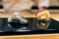 Japanese Omakase Menu: Saba Sushi Mackerel sprinkle minced Yuzu peel served by hand with pickled ginger on glossy black plate. Royalty Free Stock Photo