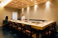 Japanese Omakase Restaurant that decorated mostly with wood. Chef cooking in kitchen counter and directly serve to customer