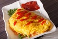 Japanese Omurice with rice, peas and ketchup close-up, horizontal