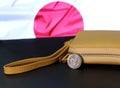 Japanese one hundred Yen coins on obverse Sakura blossoms with sand color wallet on black floor and Japan flag background Royalty Free Stock Photo