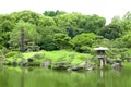 Japanese outdoor stone lantern and lake in zen garden