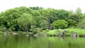 Japanese outdoor stone lantern and lake in zen garden Royalty Free Stock Photo