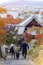 Japanese parents with child walking in a forest park of Enkoji Temple in Kyoto, Japan, during autumn