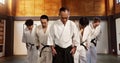 Japanese people, bow and respect in aikido in dojo place, training and modern martial arts class of self defence. Group Royalty Free Stock Photo