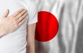 Japanese person with hand on heart on the background of Japan flag. Patriotism, country, national, pride concept Royalty Free Stock Photo