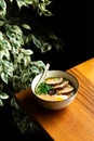 Japanese rament noodle soup in ceramic bowl with eggs and belly pork meat standing at wooden counter near the window in asian Royalty Free Stock Photo