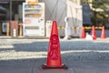 A Japanese red traffic cone adorned with a buddhist jizo bodhisattva praying with folded hands.