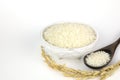 Japanese rice in ceramic cups and wooden spoons and grains of rice on isolated white background Royalty Free Stock Photo