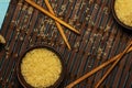 Japanese rice in a wooden bowl. Wooden chopsticks On the table of a bamboo mat. Asian cuisine. View from above. Royalty Free Stock Photo