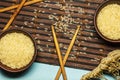 Japanese rice in a wooden bowl. Wooden chopsticks On the table of a bamboo mat. Asian cuisine. View from above. Royalty Free Stock Photo