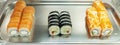 Japanese rolls on a tray on the counter. Eastern fast food. Close-up. Panorama format Royalty Free Stock Photo