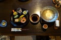 Japanese ryokan kaiseki dinner appetizer including hors d`oeuvres dishes, hot pot preparation, soy sauce bowl, liquor cup