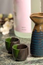 Japanese sake setup with flowers in background