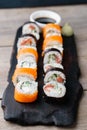 Japanese salmon sushi rolls set on wooden plate Royalty Free Stock Photo