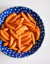 Japanese salty snack Kaki No Tane or Persimmon Seeds Sembei with Peanuts on blue plate isolated on white with a top view